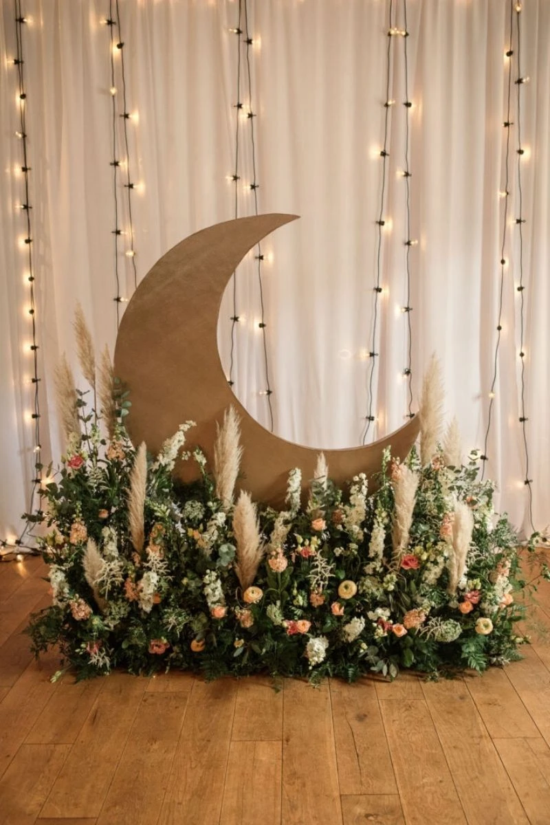 Chic floral decor with a crescent moon backdrop, perfect for booking an affordable DIY micro wedding, baby shower, or corporate event. The Boho Space Small Event Venue in Phoenix, AZ.